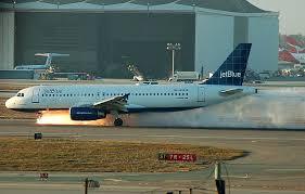 JetBlue aircraft on the runway with emergency vehicles nearby after an emergency landing.