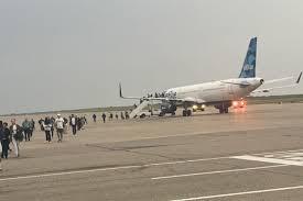  Passengers disembarking from a JetBlue aircraft on the tarmac after an emergency landing.